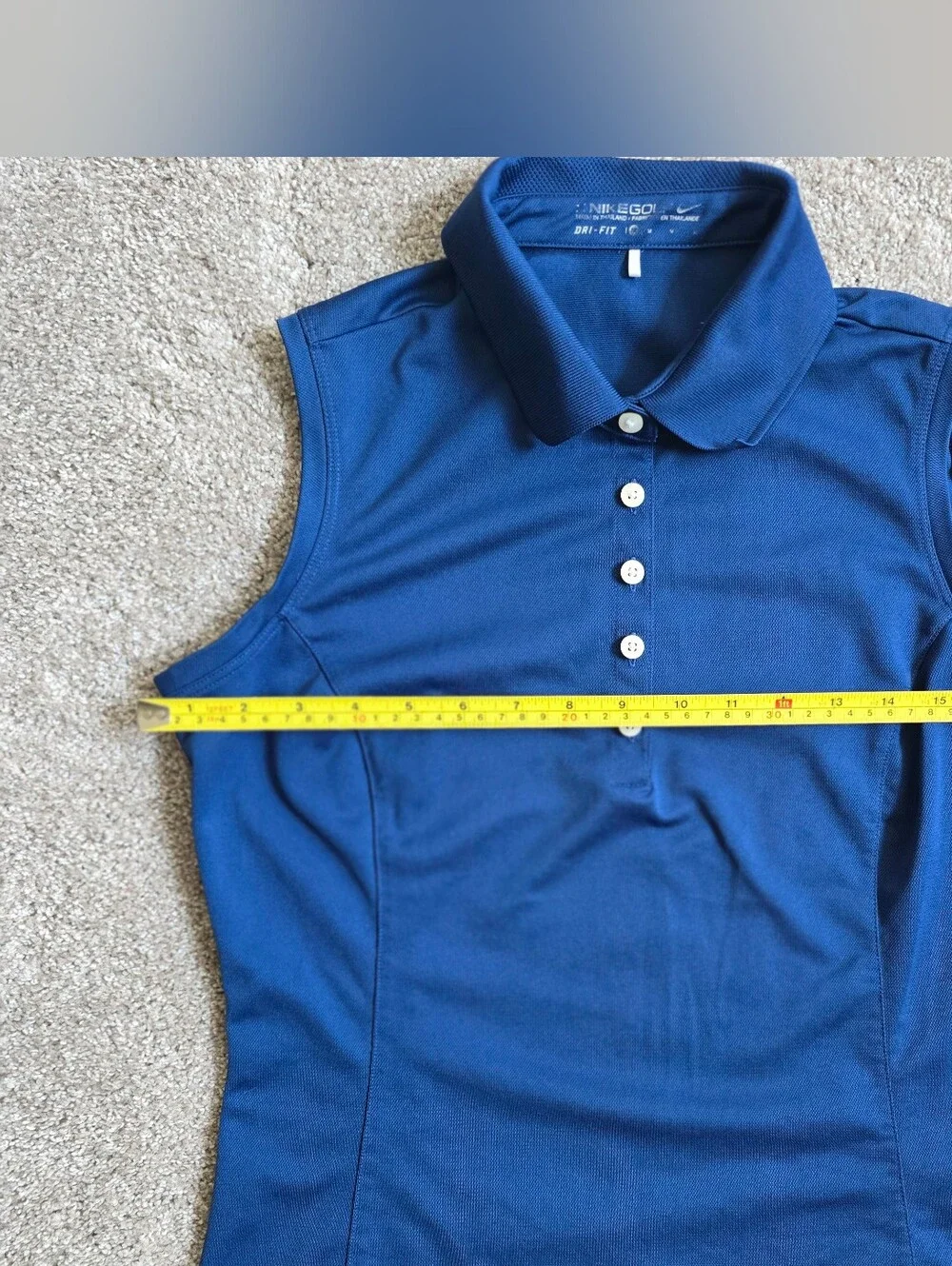 Royal blue sleeveless Nike Golf polo featuring a white-buttone